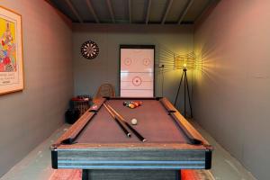a ping pong table in a room with a pool at Merryweather in Canterbury