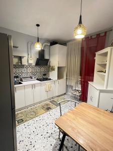a kitchen with white cabinets and a wooden table at Апартаменти біля АС-1 Зацепи in Lutsk