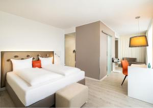 a hotel room with a bed and a chair at elaya hotel kleve, Trademark Collection by Wyndham in Kleve +90 photos