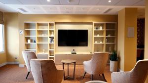 a waiting room with chairs and a flat screen tv at DOMITYS - Villa Caron - AEROPORT ORLY in Athis-Mons +5 photos
