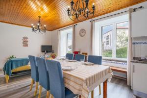 a dining room with a table and blue chairs at Gouveia Cottage in Seixal