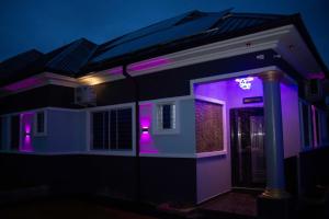 a house with purple lights in the dark at Mbre Hotel and Resorts in Uyo