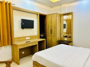 a bedroom with a bed and a flat screen tv at Hotel Silver Bricks in Amritsar