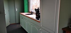 a kitchen with a sink and a window at Bed and Breakfast Op het Broek in Harfsen +10 photos