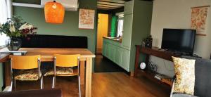 a living room with a wooden table and yellow chairs at Bed and Breakfast Op het Broek in Harfsen