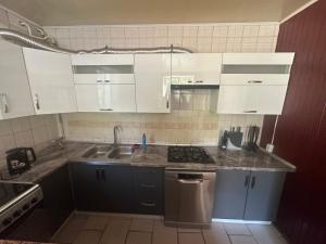 a kitchen with white cabinets and a sink at Бордуляка 11 in Ternopil