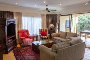 a living room with a couch and chairs and a tv at The Shores, Ramsgate in Ramsgate