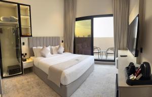 a bedroom with a large white bed and a balcony at Triple A Hotel in Riyadh +68 photos