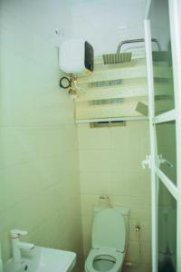 a white bathroom with a toilet and a sink at Mbre Hotel and Resorts in Uyo +17 photos