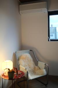 a room with a chair with a table and a lamp at PS Casa in Hasselt