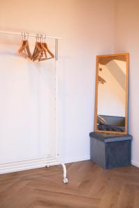 a mirror on a wall next to a shelf with shoes at PS Casa in Hasselt