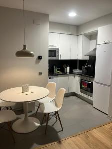 a kitchen with a table and chairs and a white refrigerator at Apartamento con encanto in Igualada
