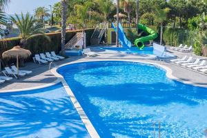 a swimming pool with a slide in a resort at Camping Enmar - Mobil home 3 pièces 4 personnes climatisé + TV MAE-5300 in Pineda de Mar