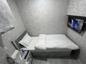 a small room with a bed and a tv at ReveL HoteL in Tashkent