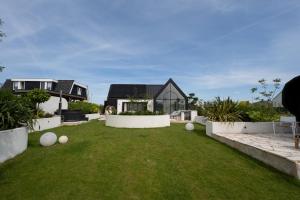 a backyard with a lawn with white walls at 8 persons Wellness Villa Tulpenacker in Roelofarendsveen