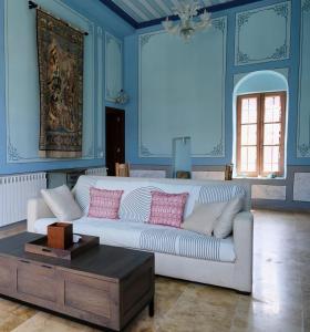 a living room with a white couch and blue walls at Spiritu in Ḩārat al Qal‘ah +1 photo