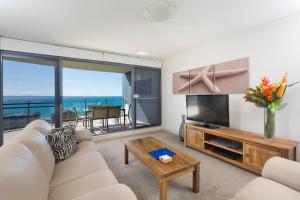 a living room filled with furniture and a tv at Sevan Apartments Forster in Forster