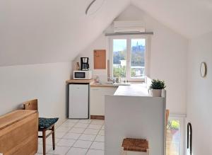 a kitchen with white appliances and a window at Aux Rives Tranquilles, appartement bord de Loire avec vue in Les Rosiers