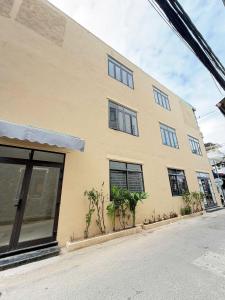 a yellow building with windows on a street at Louis Home in Danang