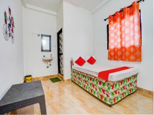 a bedroom with a bed with red pillows and a window at Hotel O RJ HOTEL INN in Pānchgaon