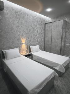 two beds in a room with a wall at ReveL HoteL in Tashkent +37 photos