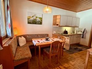 a living room with a couch and a table and a kitchen at Ferienwohnungen Pernull in Waidegg