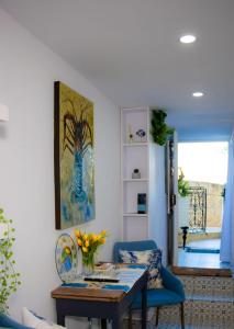 a living room with a table and a blue chair at Studio in Historic Birgu in Birgu +30 photos