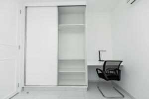 a black chair and a desk in a room at Golf View Apartments in Maputo +10 photos