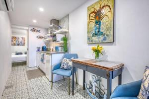 a kitchen with a desk and blue chairs in a room at Studio in Historic Birgu in Birgu