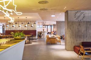 a restaurant with a clock on the wall and tables at Scandic Frankfurt Museumsufer in Frankfurt