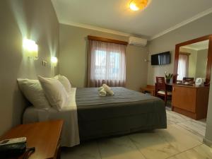 a bedroom with a bed with a teddy bear on it at Piraeus Acropole Hotel in Piraeus