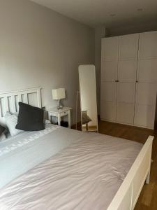 a bedroom with a large white bed with a black pillow at Apartamento con encanto in Igualada +3 photos