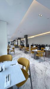 a dining room with tables and chairs in a building at Triple A Hotel in Riyadh