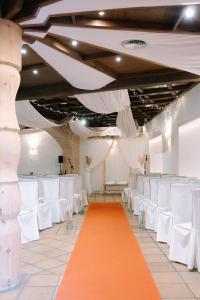 an aisle with white chairs and an orange carpet at Cella del Palancar in Motilla del Palancar
