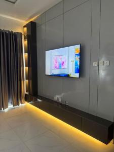 a room with a tv on a wall at Max Heights in Ikeja