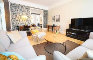 a living room with a couch and a tv and a table at Stationshuset bed and breakfast i Ed in Ed
