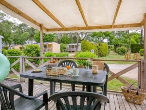 a patio with a table and chairs on a deck at ZEcamping 4 étoiles pet friendly avec piscine chauffée et pataugeoire in Nesles-la-Vallée
