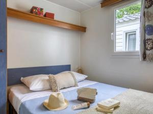 a bedroom with a bed with a hat on it at ZEcamping 4 étoiles pet friendly avec piscine chauffée et pataugeoire in Nesles-la-Vallée