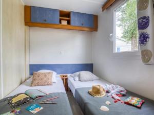 two beds in a small room with a hat on it at ZEcamping 4 étoiles pet friendly avec piscine chauffée et pataugeoire in Nesles-la-Vallée +14 photos