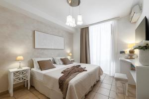 a bedroom with a large white bed and a window at Guest House Flores in Dubrovnik