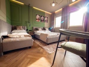 two beds in a room with green walls at Premier Rooms in Szarvas +69 photos