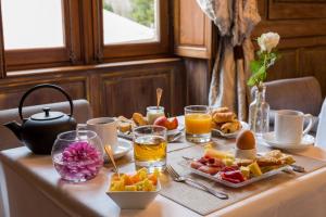 a table with a breakfast of fruit and orange juice at La Longère du Sallay in Saincaize-Meauce
