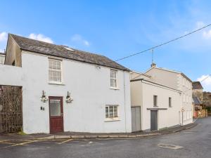 a white house with a red door on a street at Errismore House in Clifden