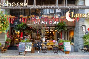 a man sitting at a table in front of a restaurant at Riverside Seahorse Danang Hotel in Danang