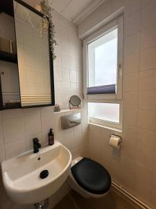 a bathroom with a sink and a toilet and a window at Ferienwohnung Weitsicht in Hüttenrode +30 photos