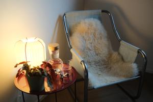 a chair with a table with a lamp and a plant at PS Casa in Hasselt