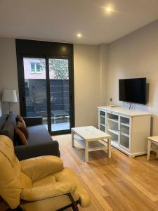 a living room with a couch and a tv at Apartamento con encanto in Igualada