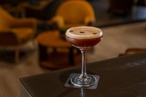 a drink in a glass sitting on a table at HF Ala Sul in Porto