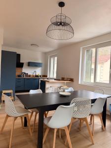a dining room with a black table and white chairs at La Bulle d Ax in Ax-les-Thermes