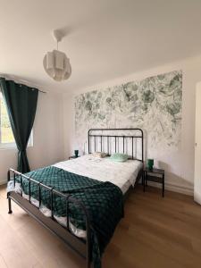 a bedroom with a bed with a green comforter at La Bulle d Ax in Ax-les-Thermes